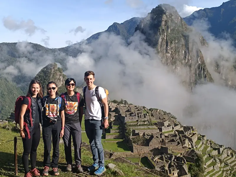 Group of hikers at Machu Picchu after completing the Inca Trail, with Huayna Picchu in the background